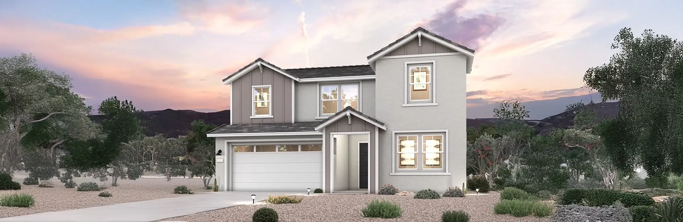 Two-story modern house with gray and white exterior, attached two-car garage, and desert landscaping, set against a sunset sky.