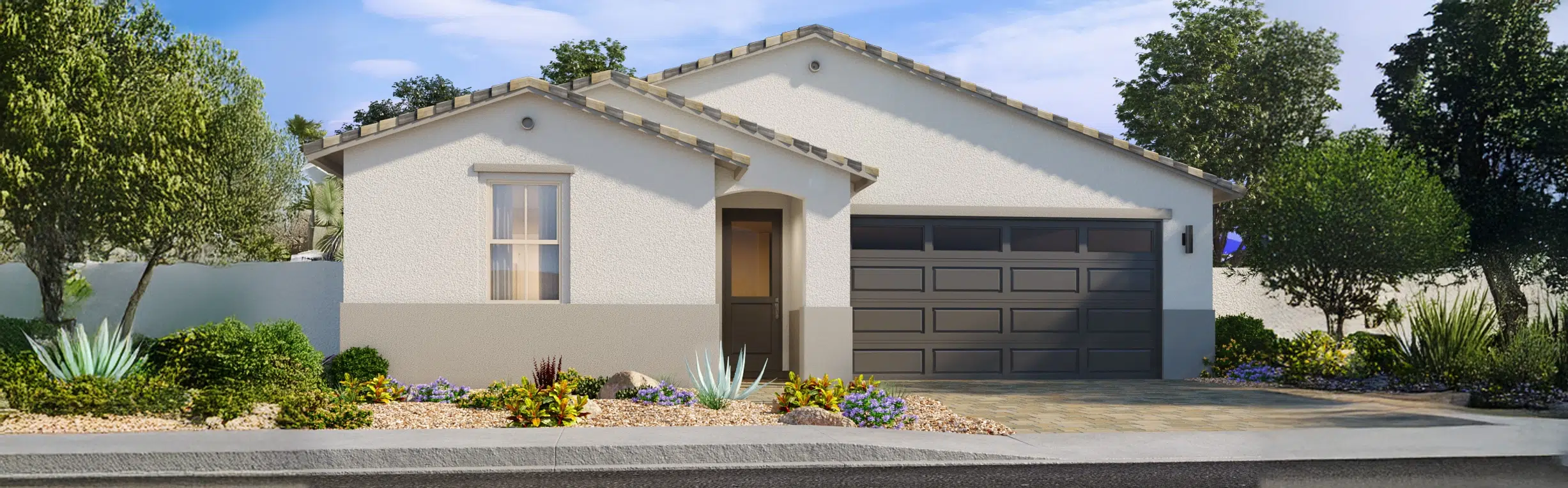 Single-story modern house with a gray garage door, light stucco exterior, tiled roof, and landscaped front yard with rocks, bushes, and trees.