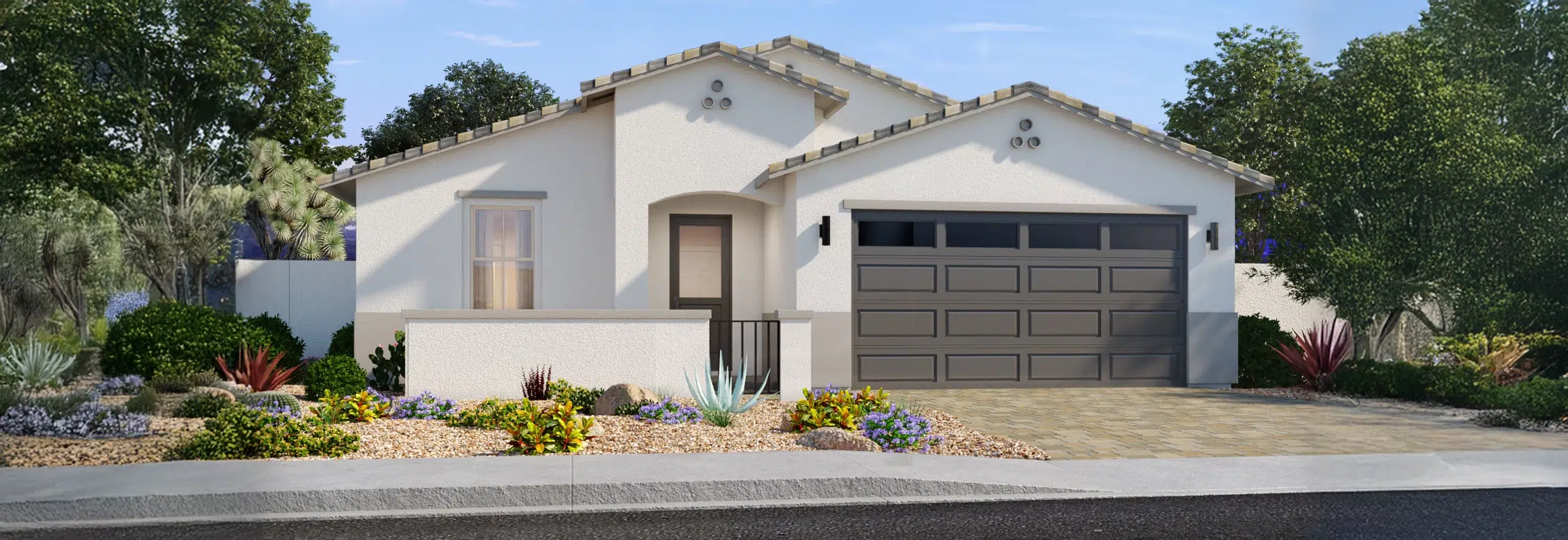 Single-story house with a tiled roof, two-car garage, desert landscaping, and a small front patio, set against a backdrop of trees and a clear sky.