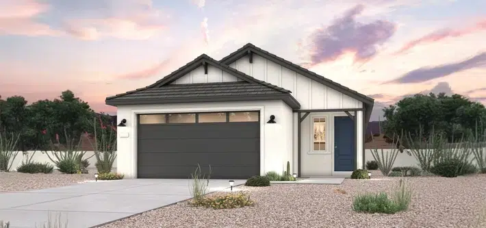 A modern single-story house with a dark garage door, blue front door, and desert landscaping, photographed at sunset.