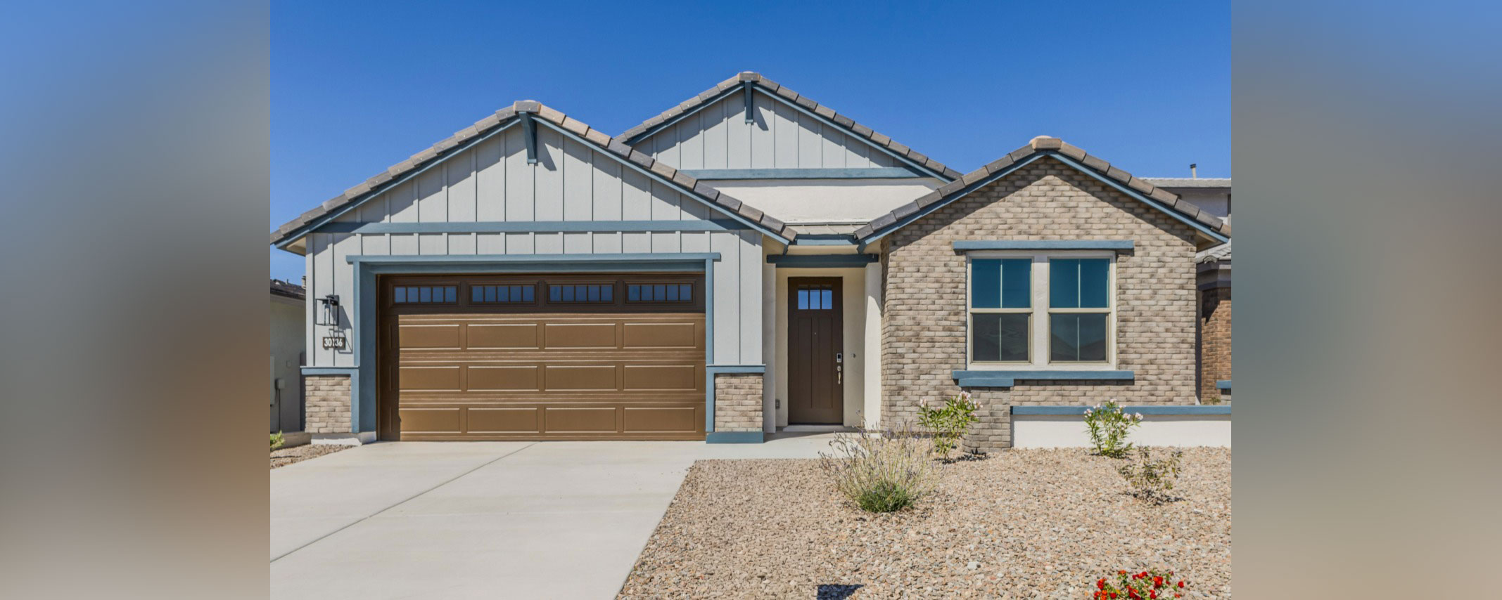 Single-story house with a brown garage door, front entrance, and a gravel front yard.