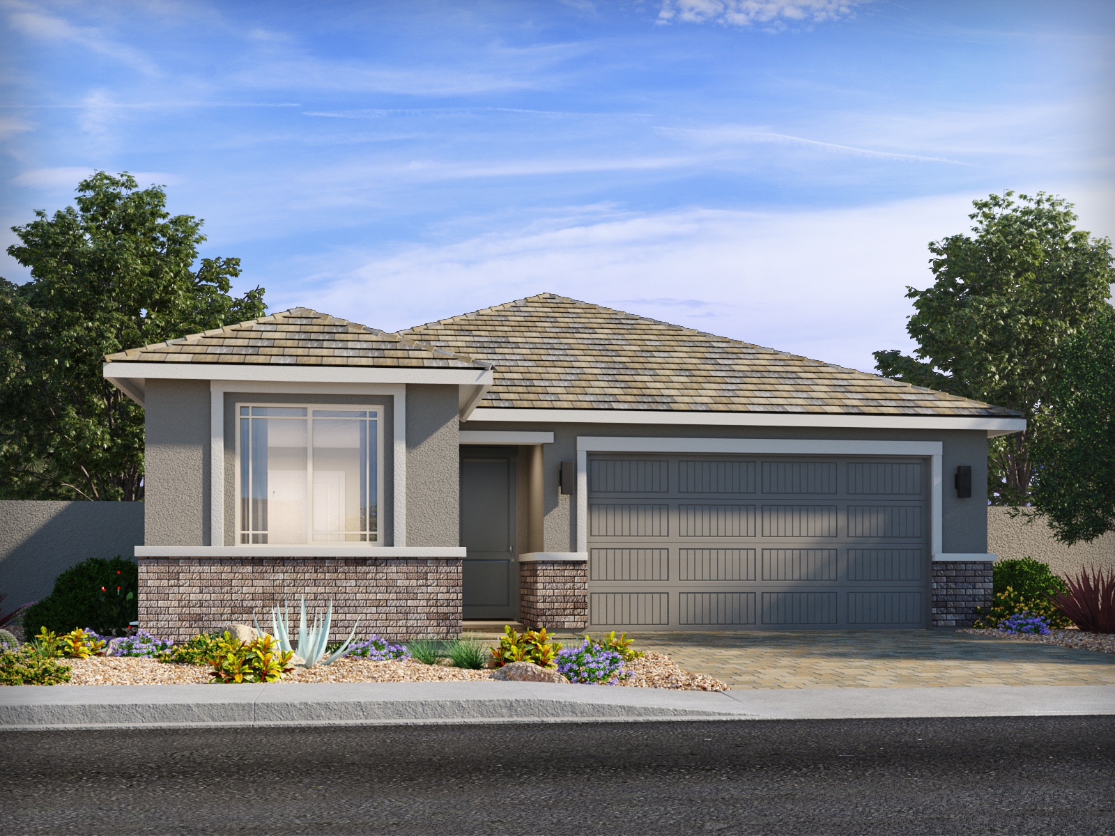 Single-story modern house with a two-car garage, gray exterior, brick accents, and desert landscaping under a blue sky with scattered clouds.