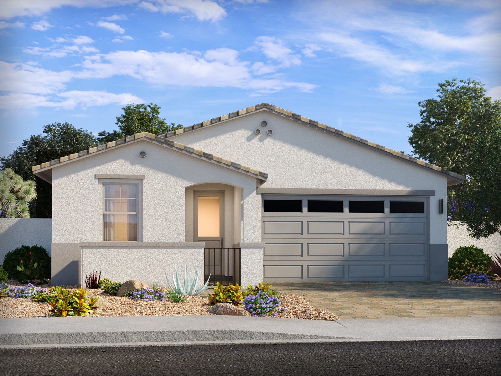 Single-story house with a white exterior, gray tiled roof, attached two-car garage, desert landscaping, and a paved driveway under a blue sky with scattered clouds.