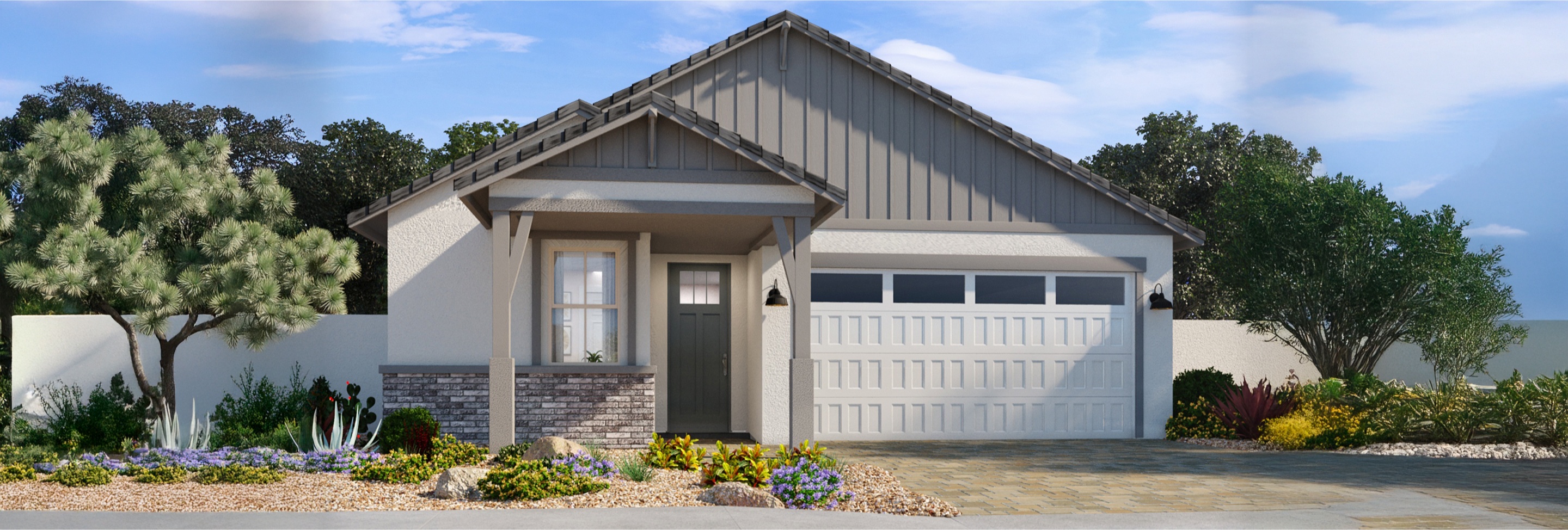 Single-story house with gray siding and shingle roof, white garage door, small front porch, and landscaped yard with rocks and shrubs.