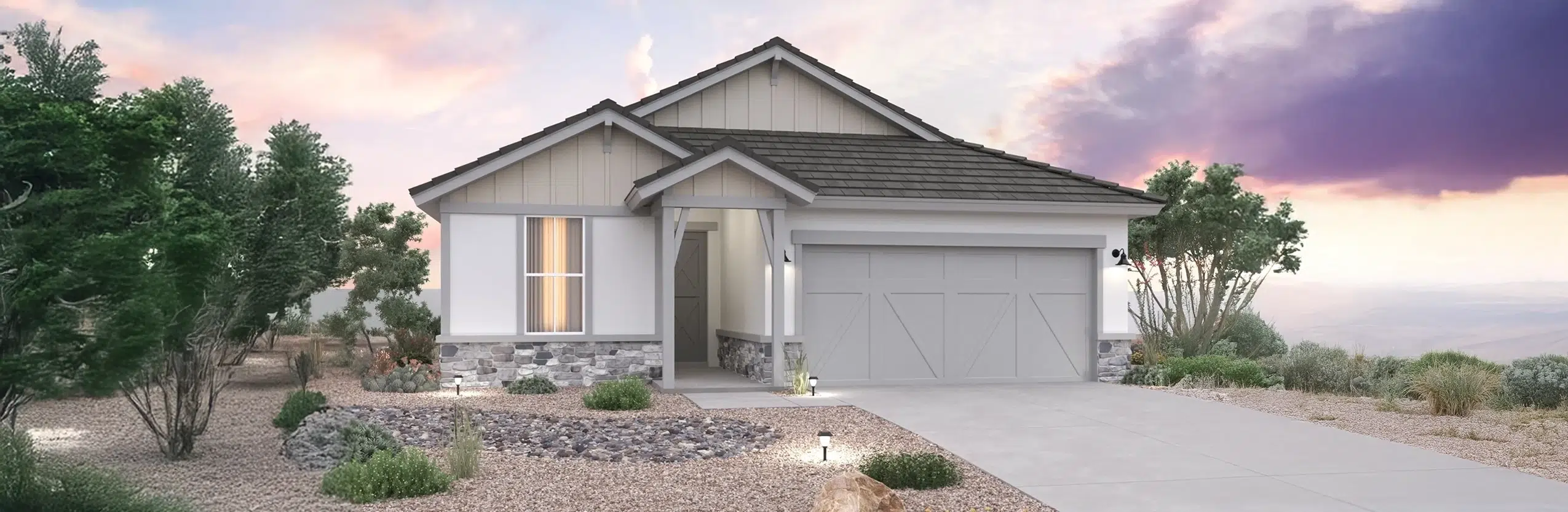 Single-story suburban house with a two-car garage, desert landscaping, and exterior lights on at dusk under a partly cloudy sky.