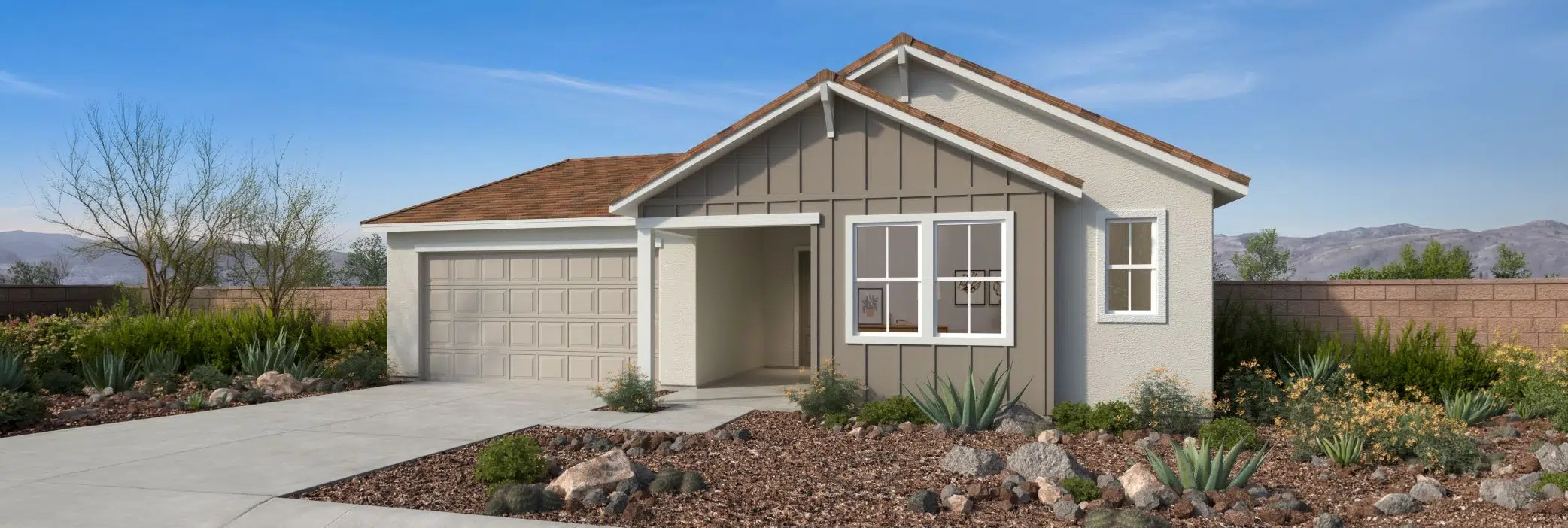 Single-story house with a two-car garage, gabled roof, light exterior, and xeriscaped front yard featuring rocks and desert plants under a clear sky.