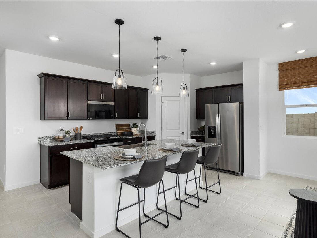 Modern kitchen with dark wood cabinets, stainless steel appliances, granite countertops, three pendant lights, and four black barstools at a central island.