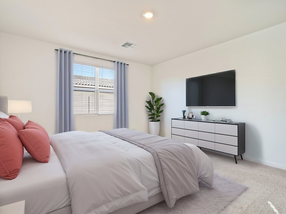Modern bedroom with a bed, pastel pillows, light gray bedding, a dresser with decor, a large TV, a plant, and a window with blue curtains letting in natural light.
